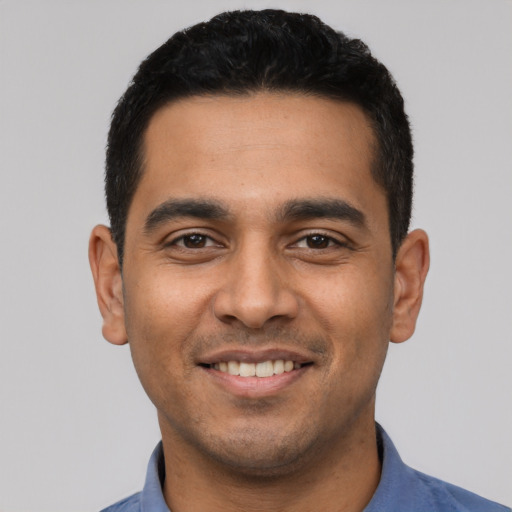 Joyful latino young-adult male with short  black hair and brown eyes