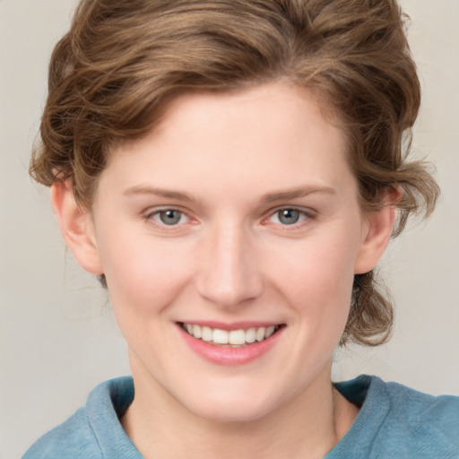 Joyful white young-adult female with medium  brown hair and blue eyes