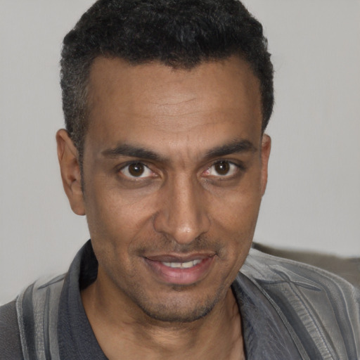 Joyful black young-adult male with short  black hair and brown eyes