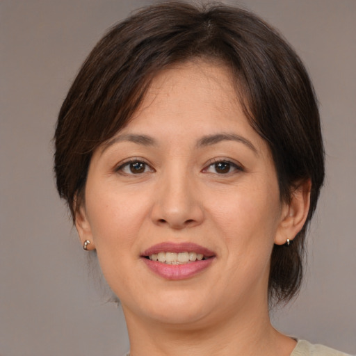 Joyful asian adult female with medium  brown hair and brown eyes