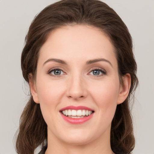 Joyful white young-adult female with medium  brown hair and green eyes