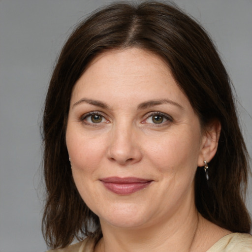 Joyful white adult female with medium  brown hair and grey eyes