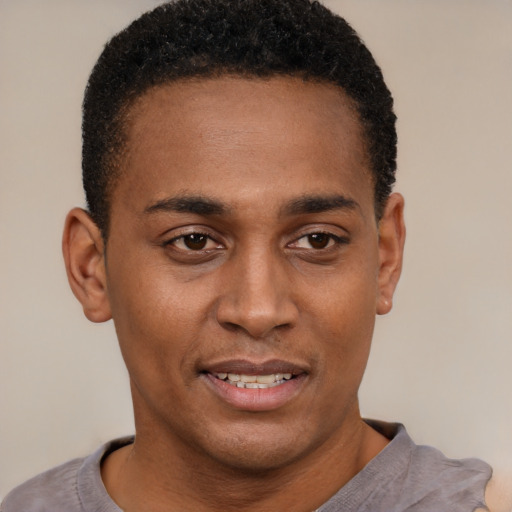 Joyful black young-adult male with short  black hair and brown eyes