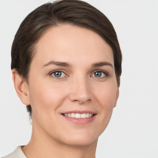 Joyful white young-adult female with short  brown hair and grey eyes