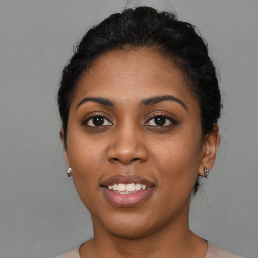 Joyful black young-adult female with short  black hair and brown eyes