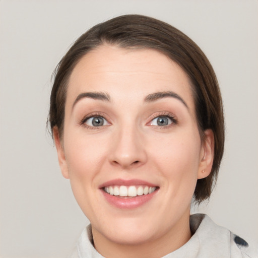 Joyful white young-adult female with medium  brown hair and green eyes