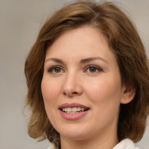 Joyful white young-adult female with medium  brown hair and green eyes