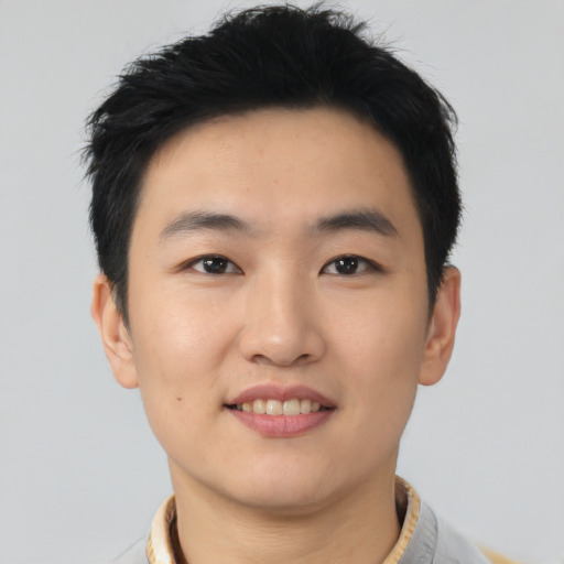 Joyful asian young-adult male with short  black hair and brown eyes