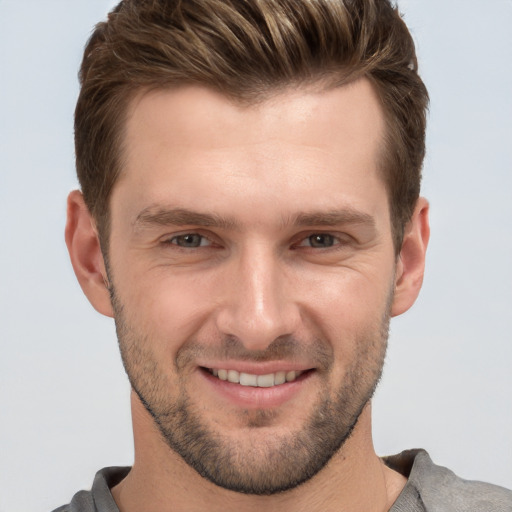 Joyful white young-adult male with short  brown hair and grey eyes