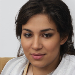 Joyful latino young-adult female with medium  brown hair and brown eyes