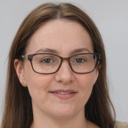 Joyful white adult female with long  brown hair and grey eyes