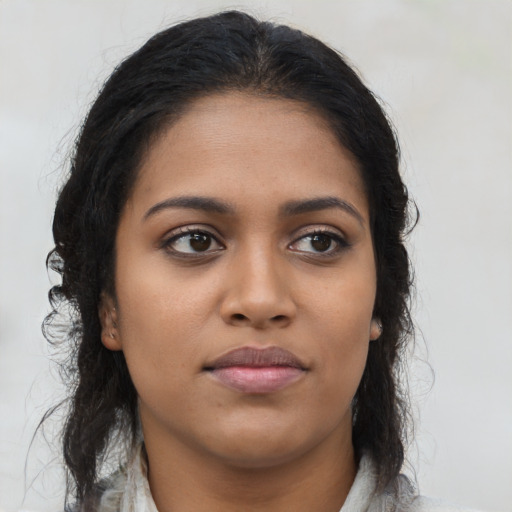 Joyful black young-adult female with long  brown hair and brown eyes