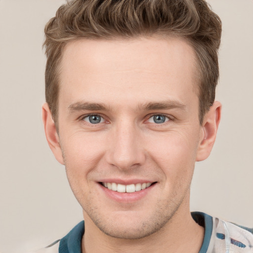 Joyful white young-adult male with short  brown hair and grey eyes