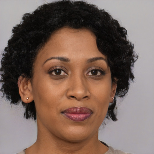 Joyful black adult female with short  brown hair and brown eyes