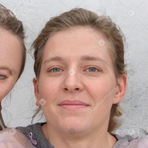 Joyful white young-adult female with medium  brown hair and blue eyes