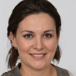 Joyful white adult female with medium  brown hair and brown eyes