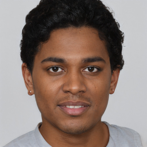 Joyful black young-adult male with short  brown hair and brown eyes