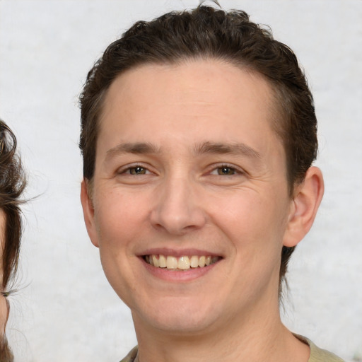 Joyful white adult male with medium  brown hair and brown eyes