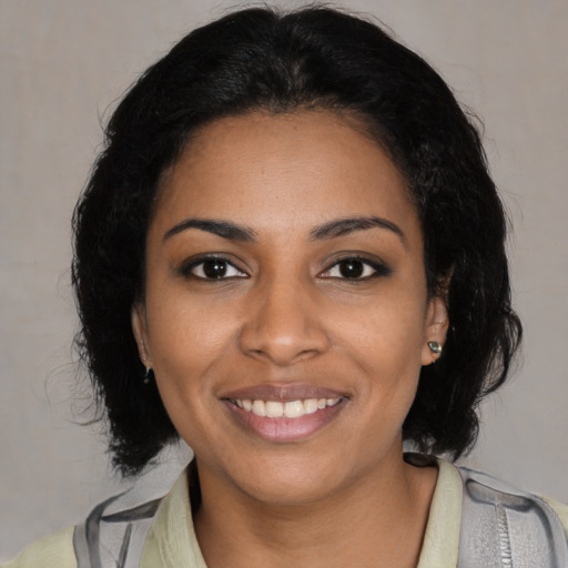 Joyful black young-adult female with medium  brown hair and brown eyes