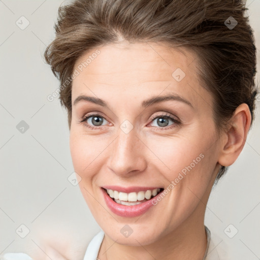 Joyful white young-adult female with short  brown hair and grey eyes