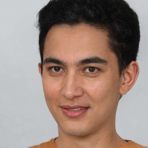 Joyful latino young-adult male with short  brown hair and brown eyes