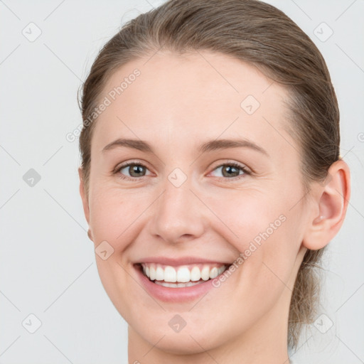 Joyful white young-adult female with medium  brown hair and grey eyes