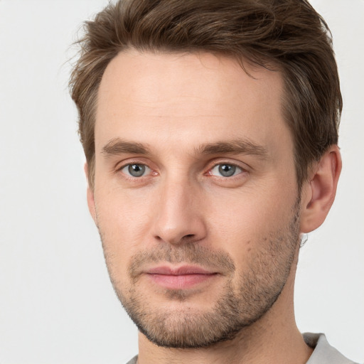 Joyful white young-adult male with short  brown hair and grey eyes