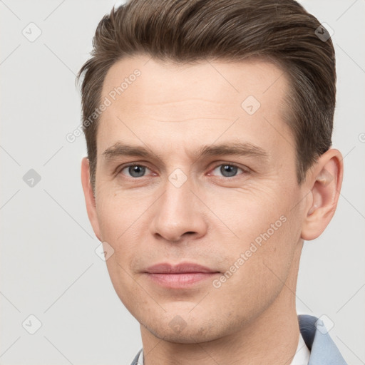 Joyful white young-adult male with short  brown hair and grey eyes