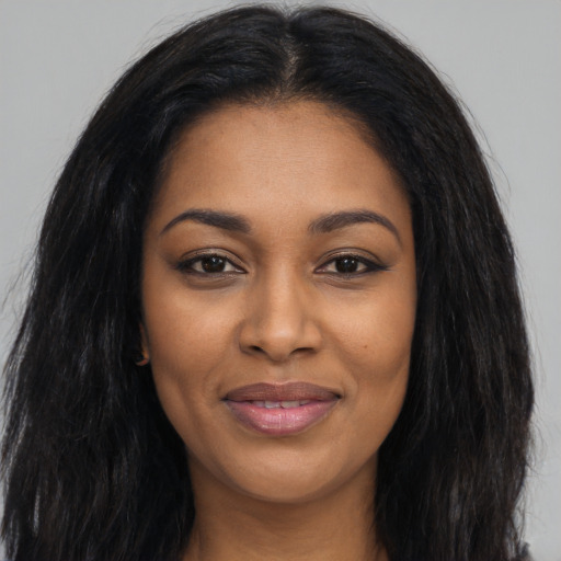 Joyful black young-adult female with long  black hair and brown eyes