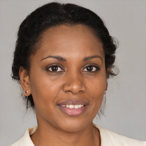 Joyful black young-adult female with medium  brown hair and brown eyes