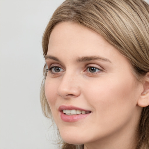 Joyful white young-adult female with long  brown hair and blue eyes