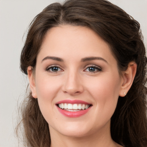 Joyful white young-adult female with long  brown hair and grey eyes