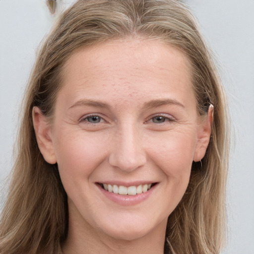 Joyful white young-adult female with long  brown hair and blue eyes