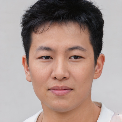 Joyful asian young-adult male with short  brown hair and brown eyes