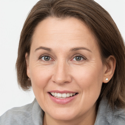 Joyful white adult female with medium  brown hair and grey eyes