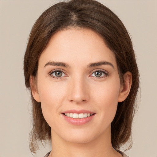 Joyful white young-adult female with medium  brown hair and green eyes