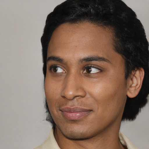 Joyful black young-adult male with short  black hair and brown eyes
