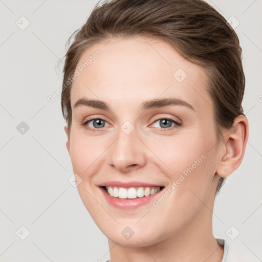 Joyful white young-adult female with short  brown hair and grey eyes