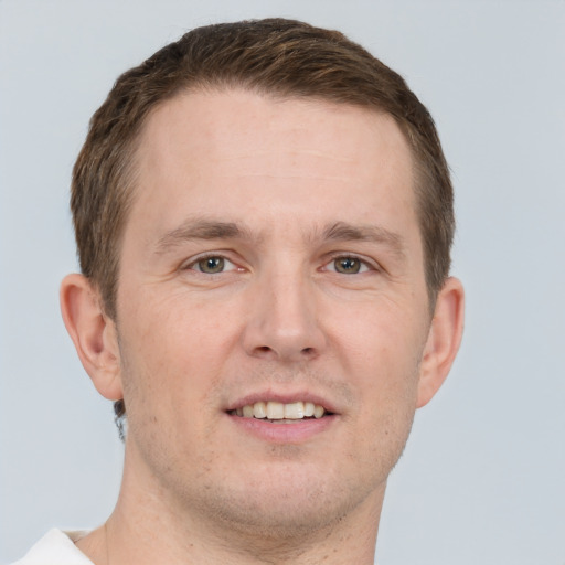 Joyful white adult male with short  brown hair and grey eyes