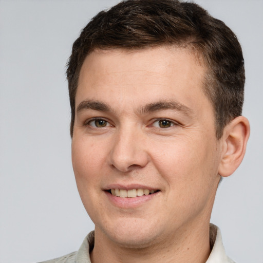 Joyful white young-adult male with short  brown hair and brown eyes