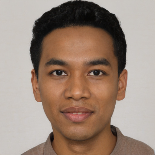 Joyful latino young-adult male with short  black hair and brown eyes