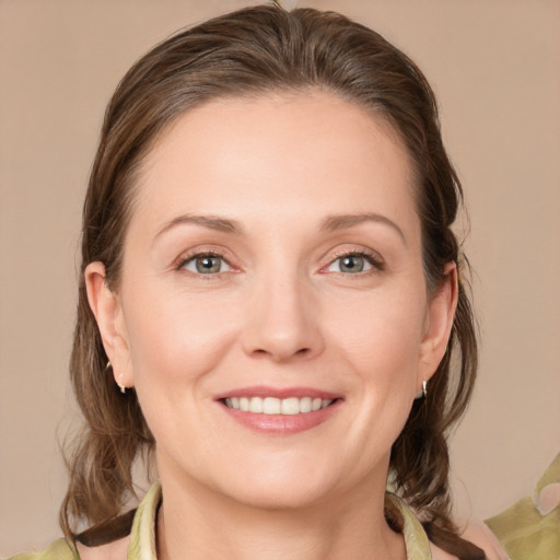 Joyful white young-adult female with medium  brown hair and grey eyes