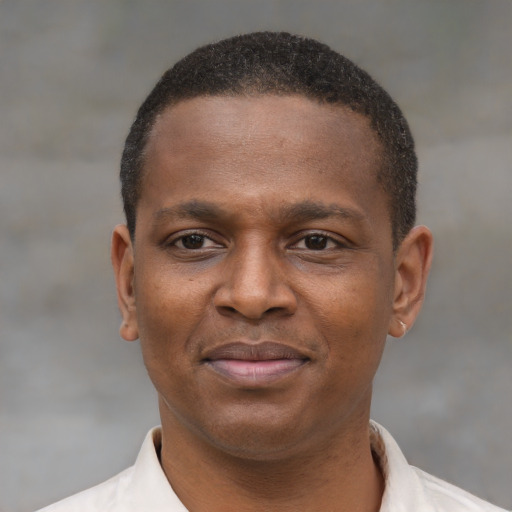 Joyful latino young-adult male with short  brown hair and brown eyes