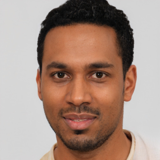 Joyful black young-adult male with short  black hair and brown eyes