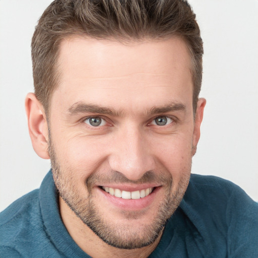 Joyful white young-adult male with short  brown hair and grey eyes