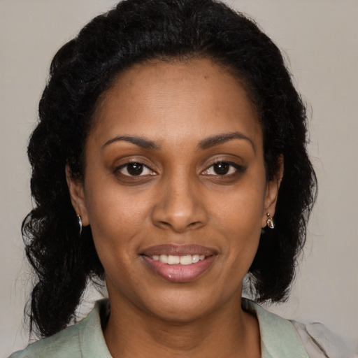 Joyful black young-adult female with long  brown hair and brown eyes