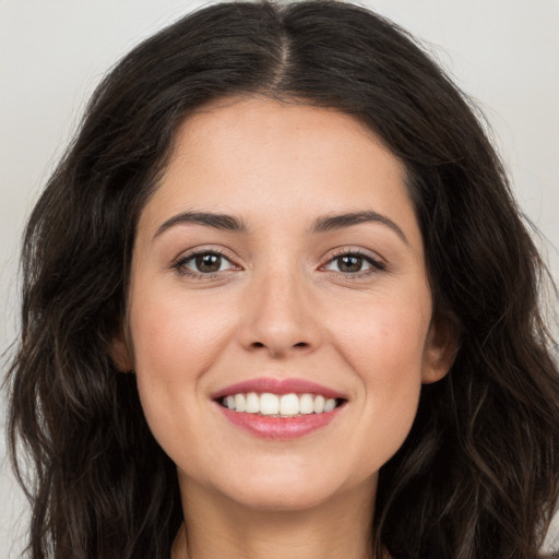 Joyful white young-adult female with long  brown hair and brown eyes