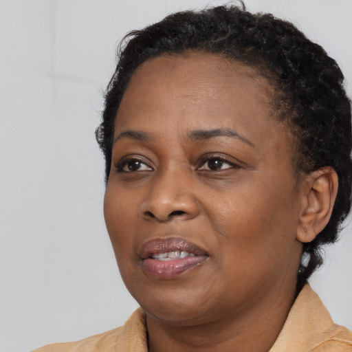 Joyful black young-adult female with short  black hair and brown eyes