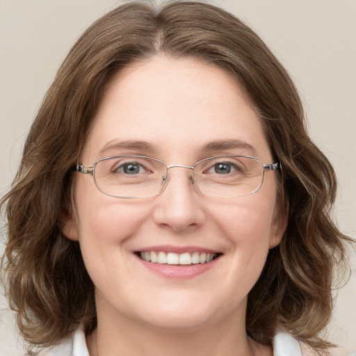 Joyful white adult female with medium  brown hair and blue eyes