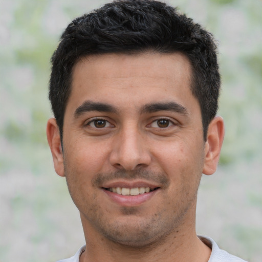 Joyful white young-adult male with short  black hair and brown eyes